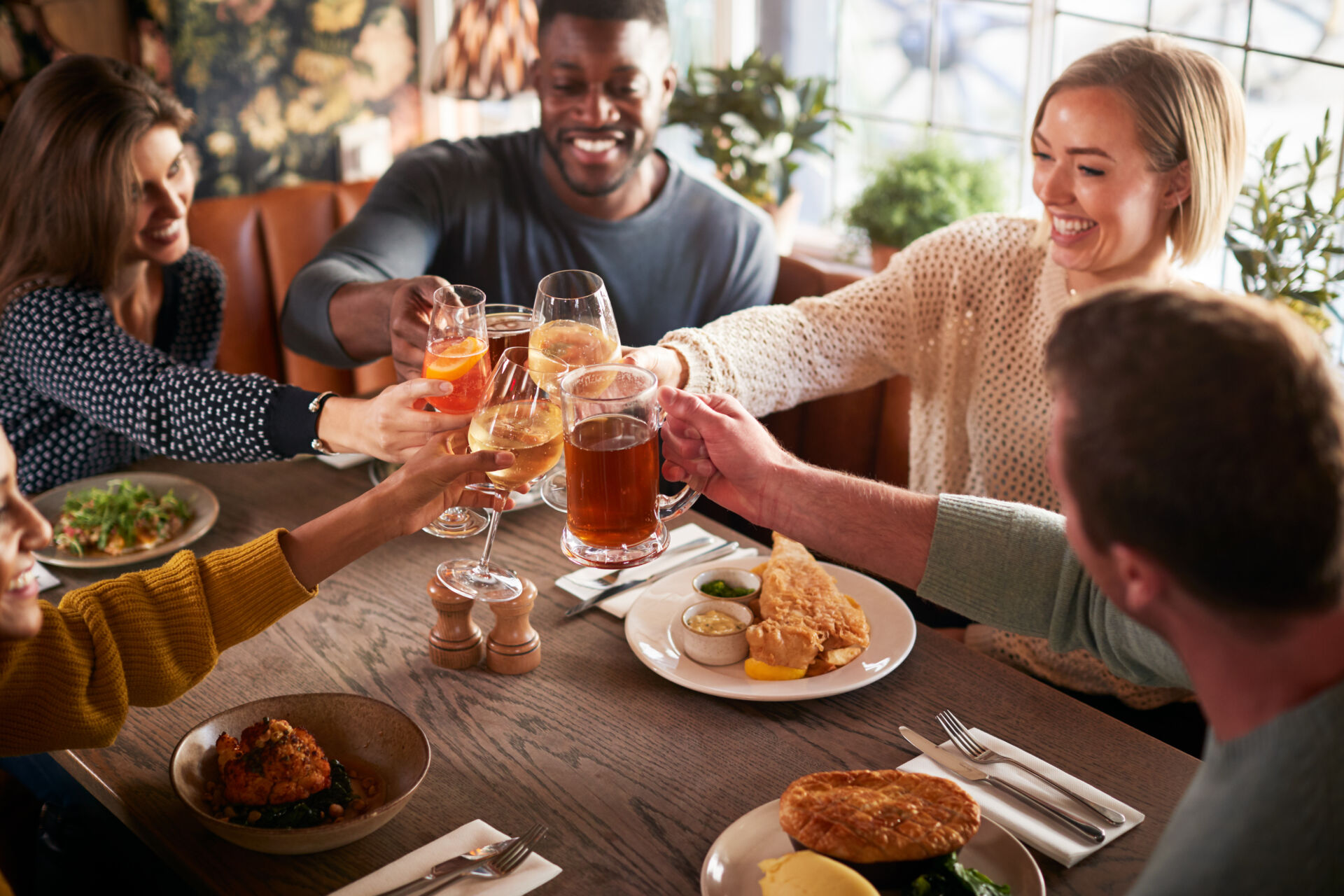 People at gastro pub in Bridge making toast together